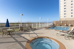 A rooftop pool area with lounge chairs, a hot tub, and a view of the beach. - 🏖️The Peachy Pelican~Gulf Views~Hot Tub~Private Beach Access Steps to Dining🏖️ (Destin)