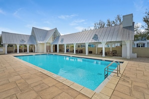 A swimming pool with a covered seating area and a building with a sloped roof. - 🚲Willow & Waves | Golf Cart, 4 Bikes, Pool, Near Beach🏊 (Inlet Beach)