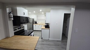 A compact kitchen with a microwave, refrigerator, and a small countertop.