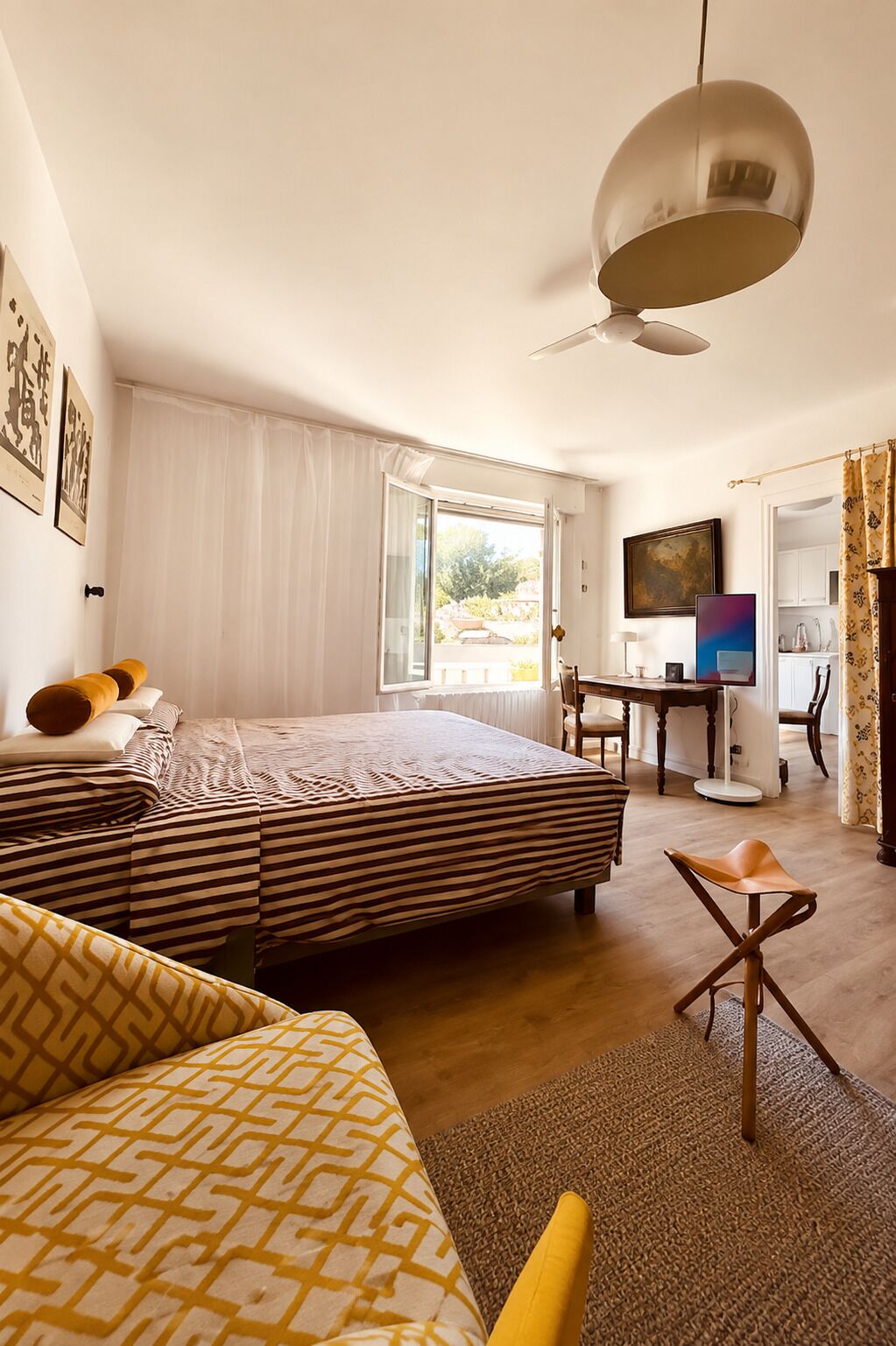 Hotellihuone, jossa on sänky, työpöytä, tuoli ja televisio.
