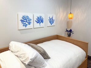 A bedroom with a wooden headboard, white bedding, and three blue artwork pieces on the wall. - 3BR Tulum Jungle Oasis with Private Terrace (Tulum)