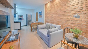 A modern living room with a sofa, dining table, and kitchen in the background. - Beautiful apartment in Copacabana near the beach. (Rio de Janeiro)