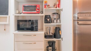 A compact kitchen with a microwave, coffee maker, and a refrigerator. - Beautiful apartment in Copacabana near the beach. (Rio de Janeiro)