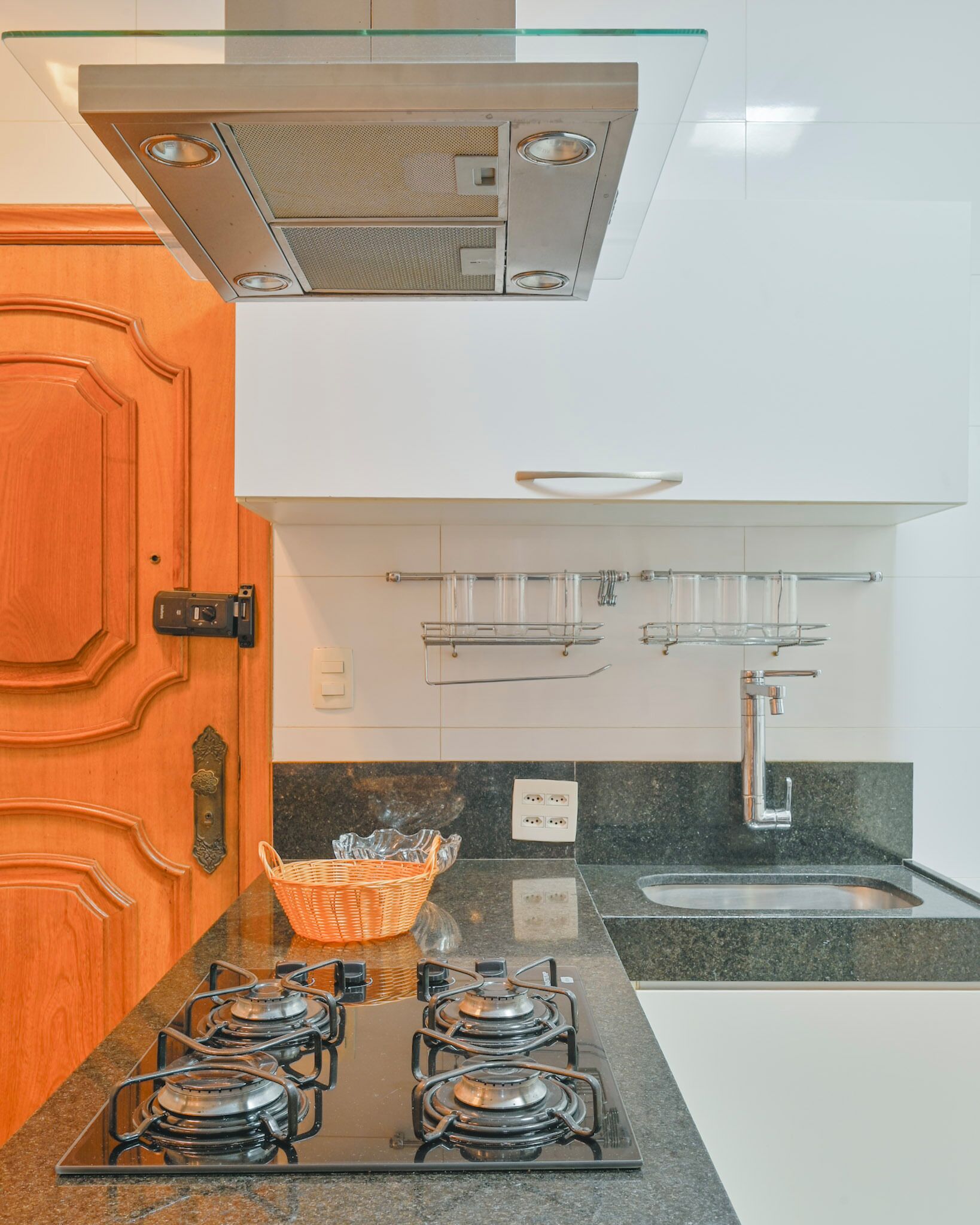 Una cocina con estufa a gas, pileta y extractor.