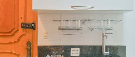 Une cuisine Ă©quipĂ©e dâune cuisiniĂšre Ă gaz, dâun Ă©vier et dâune hotte aspirante.