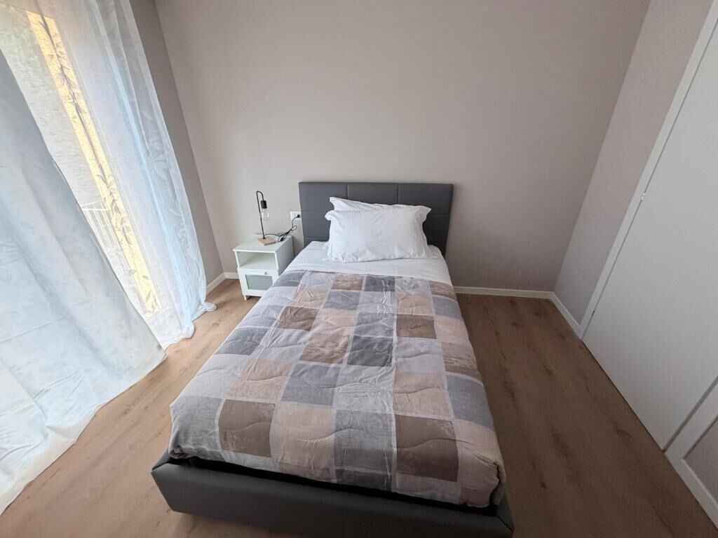 Une chambre à coucher avec un lit, une table de chevet et une commode.