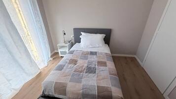 Une chambre à coucher avec un lit, une table de chevet et une commode.
