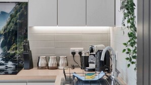 A modern kitchen with a sink, countertop, and a view of a mountainous landscape. - 3 Bed - Nr Edinburgh - Free Parking -Garden -Wi-Fi (Oakley)
