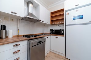 A modern kitchen with white cabinetry, stainless steel appliances, and wooden countertops. - Bosphorus View with Balcony - 3 Bedrooms 2 Bathrooms (İstanbul)