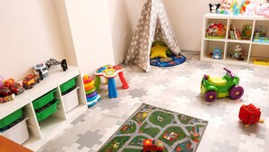 A child's playroom with a puzzle mat, toys, and storage units. - Studio for 3 People, Rewal (Rewal)