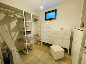 A neatly organized room with a wardrobe, drawers, and a television on the wall. - Dimora Rosara, Ocean View (Puglia)