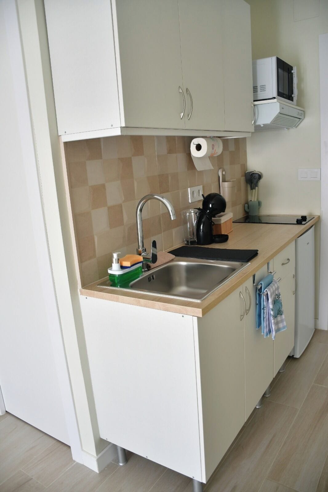 A kitchen with a sink, a microwave, and a coffee maker.