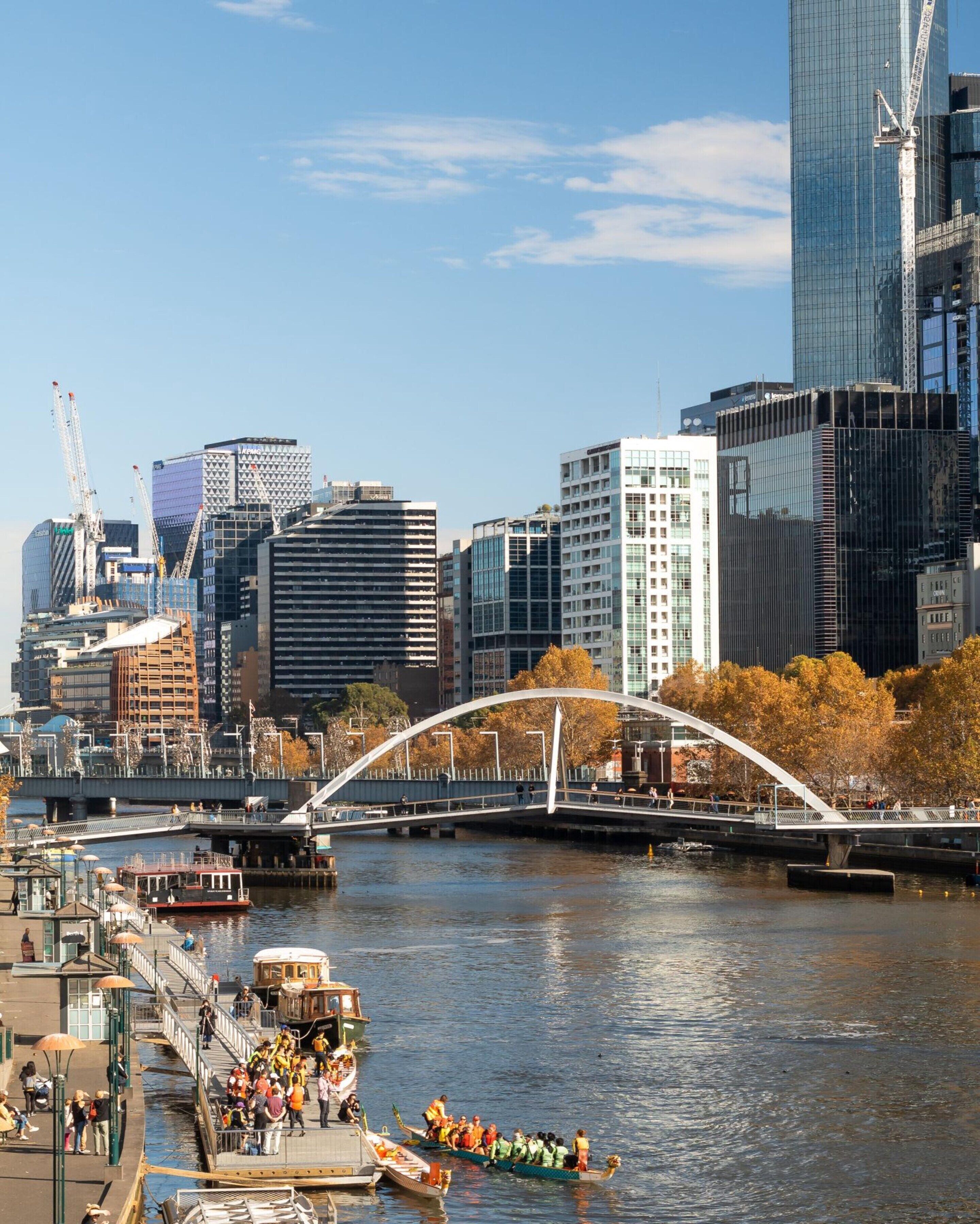 A river with boats and a bridge in a cityscape with modern buildings.