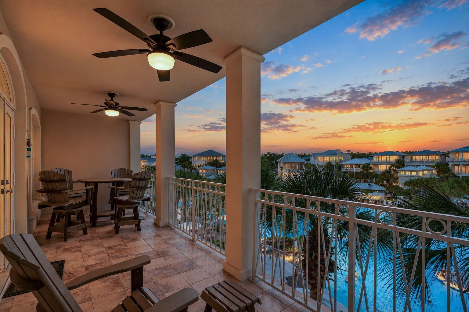 A balcony with a pool, chairs, and a table.