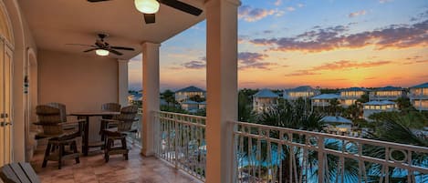 A balcony with a pool, chairs, and a table.