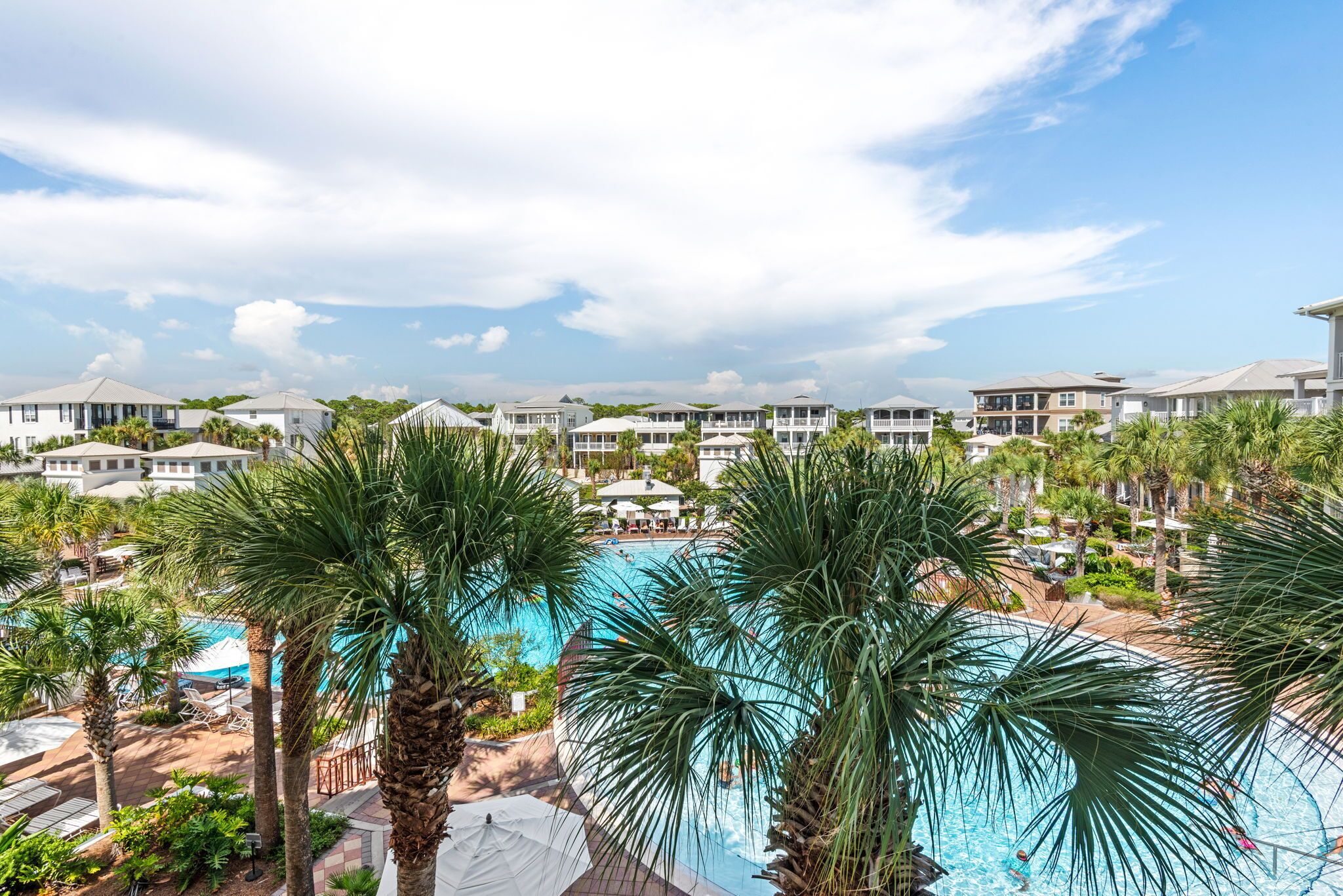 Ein Resort mit einem Swimmingpool, umgeben von Palmen und mehrstöckigen Gebäuden.