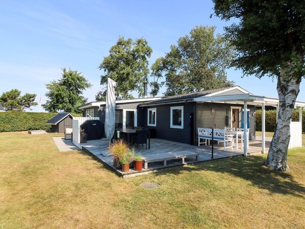 A single-story house with a patio, a barbecue grill, and a covered outdoor seating area. - 8 Person Holiday Home in Hadsund (Hadsund)