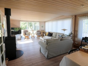 A cozy living room with a fireplace, comfortable seating, and a television. - 8 Person Holiday Home in Hadsund (Hadsund)