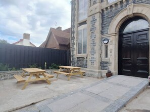 A stone building with a black door and a ramp leading to the entrance.