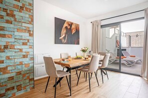 Un comedor con una mesa de madera, sillas y un cuadro de un elefante.