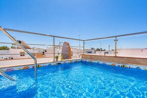 Ein Pool auf dem Dach mit blauem Himmel im Hintergrund.