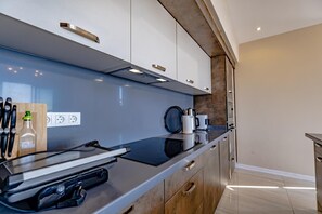 Een moderne keuken met een zwart aanrecht, houten kastjes en een ingebouwde oven.