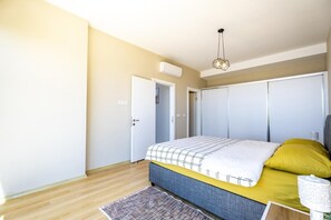 A bedroom with a bed, a bedside table, a lamp, and a door. - Villa Nerea - Three Bedroom Villa, Sleeps 6 (Geriş Mahallesi)
