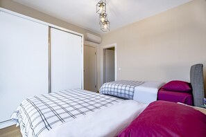 Ein Schlafzimmer mit zwei Betten, einem Kleiderschrank und einer Deckenleuchte.