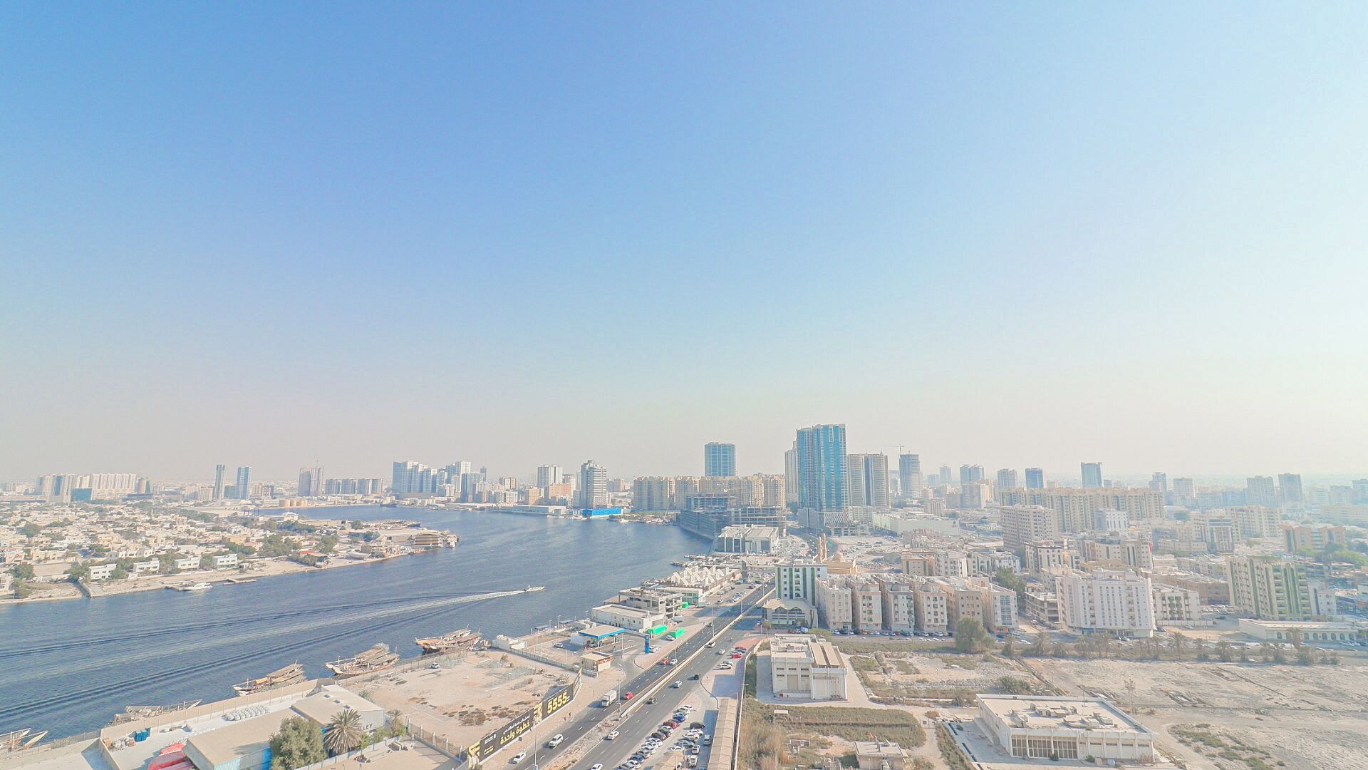 A cityscape with a river, high-rise buildings, and a bridge.