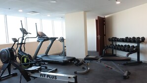 Ett gym med konditionsmaskiner, hantlar och utrustning för styrketräning.