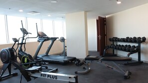 Ein Fitnessstudio mit Laufbändern, Hanteln und Krafttrainingsgeräten.