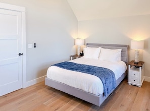 A bedroom with a bed, bedside tables, and lamps. - Lakeside 2-bedroom condo in awesome Laconia (Laconia)