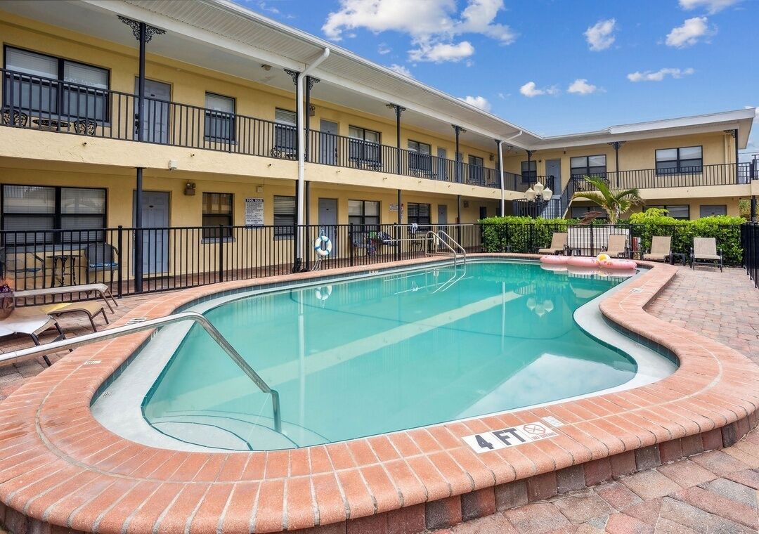 Un hôtel doté d’une piscine, d’un espace extérieur aménagé et d’un bâtiment à deux étages.