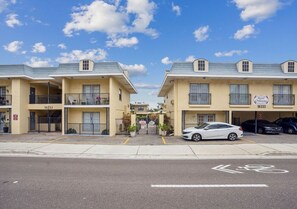 A row of two-story buildings with balconies, numbered 16333, and a bicycle lane in the foreground. - Sandy Bottoms Beach Vacation - Steps from Redington Beach! (Redington Beach)