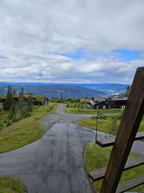 A rural road leading to a cluster of houses with a mountainous backdrop. - Modern ski-in-ski-out Apartment with Sauna–Hafjell (Øyer)