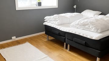 Une chambre à coucher avec un lit, une fenêtre, une lampe de chevet et un tapis blanc.