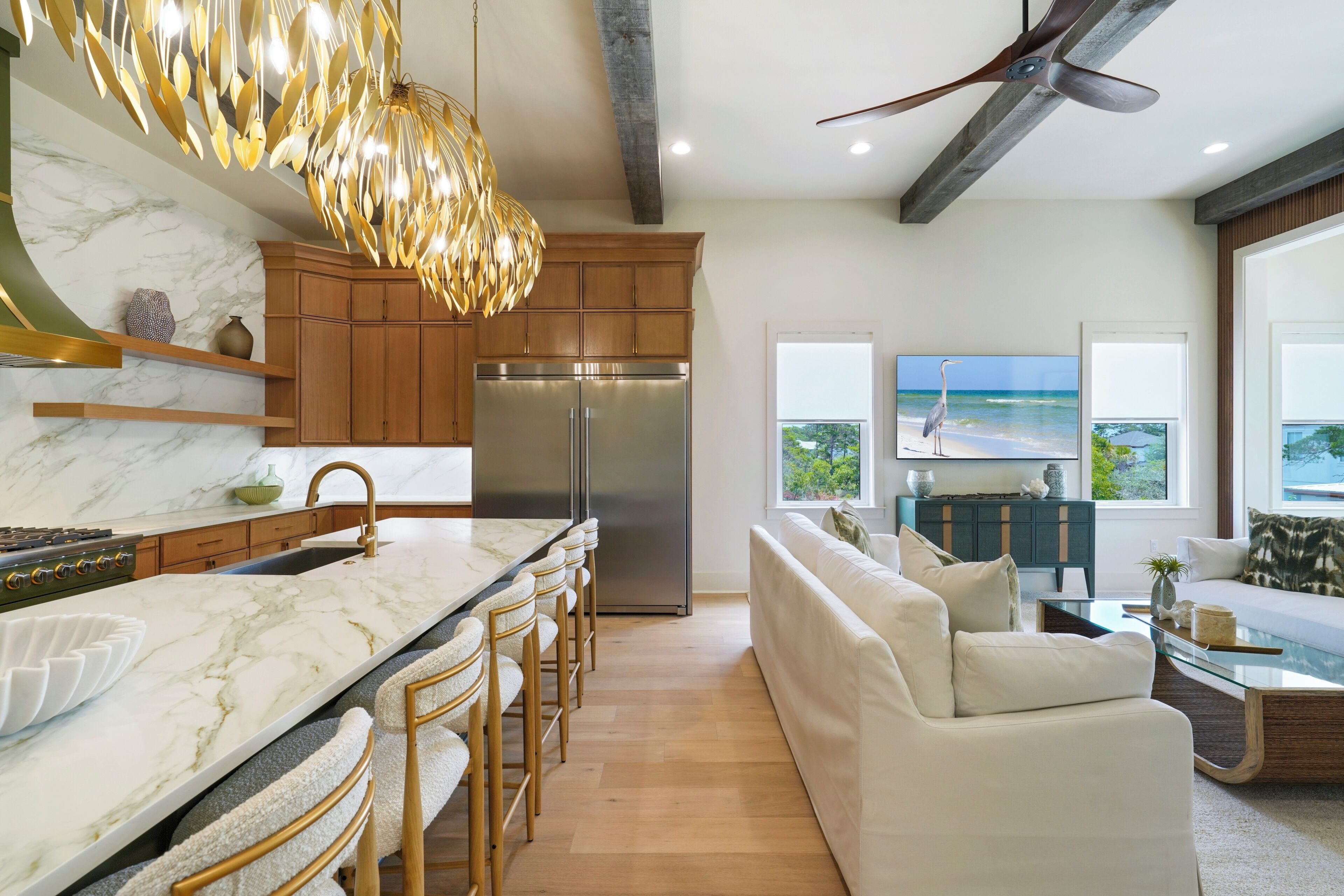 A modern kitchen with a marble countertop, wooden cabinets, and a built-in refrigerator.