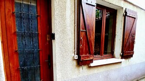 Ein Gebäude mit roter Tür und hölzernen Fensterläden.