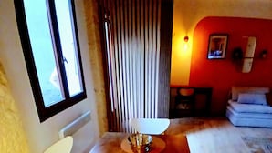 Ein Essbereich mit Holztisch und -stühlen, einem Fenster und einer roten Wand mit einem Bild.