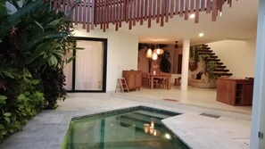 Ein modernes Interieur mit Pool, Essbereich und Treppe.