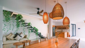 A modern interior with a staircase, dining area, and kitchen. -  Villa Merman | 3BR w BBQ Deck & Pool In Pererenan (Bali)