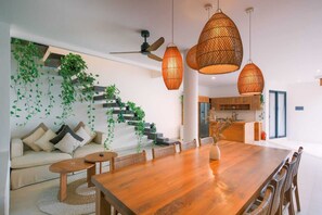 Ein modernes Interieur mit Treppe, Essbereich und Küche.