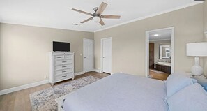 A bedroom with a bed, a dresser, a ceiling fan, and a mirror. - Terrific 3-bedroom house in Port St. Joe with boat and camper parking (Port St. Joe)