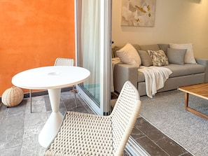 A modern living area with a round white table, wicker chairs, a grey sofa, and a wooden coffee table. - 3BR Tulum Jungle Retreat with Private Patio (Tulum)