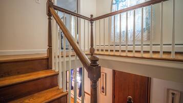 A wooden staircase with white railings and a view of the lower level.
