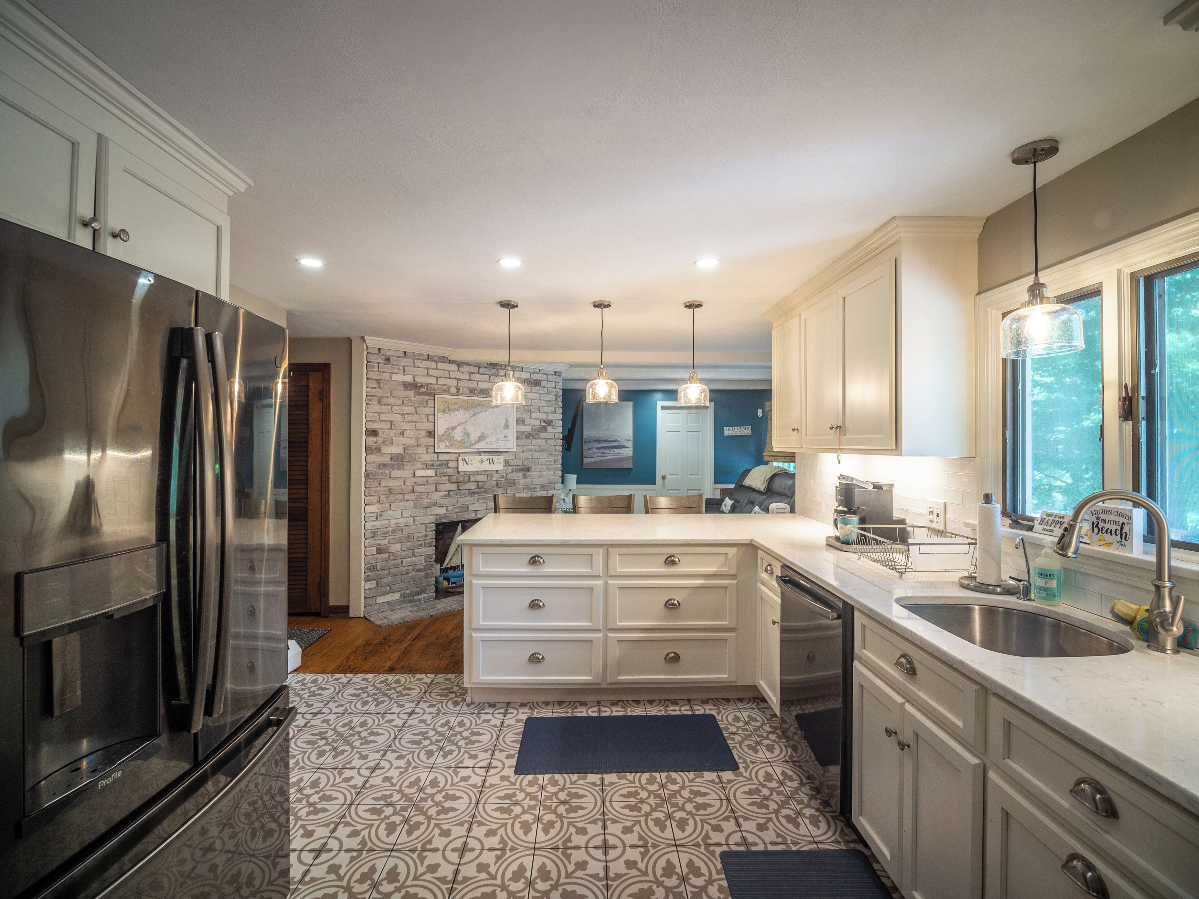 A modern kitchen with stainless steel appliances, a central island, and pendant lighting.