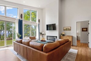 Ein modernes Wohnzimmer mit einer Ledersofa, einem Flachbildfernseher und einem Kamin.