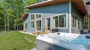 Ett hus med en bubbelpool på bakgården, en terrass och en trätrappa som leder till entrén.