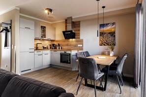 Eine moderne Küche mit weißen Schränken, einer Holz Arbeitsplatte und einem eingebauten Backofen.