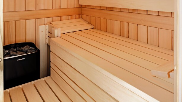 A wooden sauna with benches and a heater. - A Getaway in Büsum - Vacation Home with Sauna & Fireplace (Büsum)